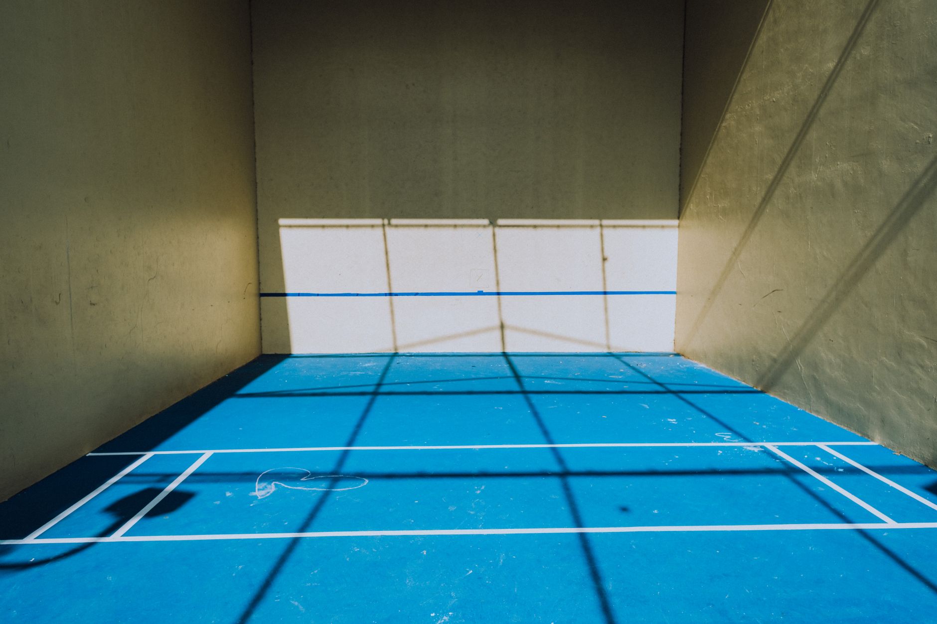 Indoor squash court at a UK multi-sport complex with glass back wall